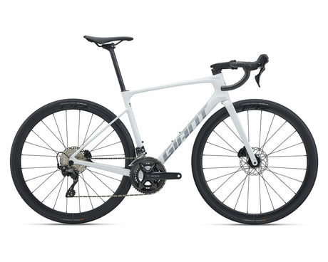 A white Giant road bicycle with black components, including the wheels, saddle, handlebars, and drivetrain, shown from a side profile on a white background.