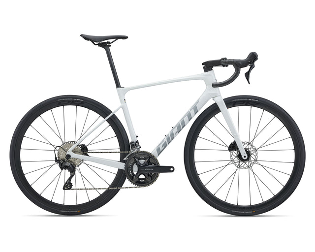 A white Giant road bicycle with black components, including the wheels, saddle, handlebars, and drivetrain, shown from a side profile on a white background.