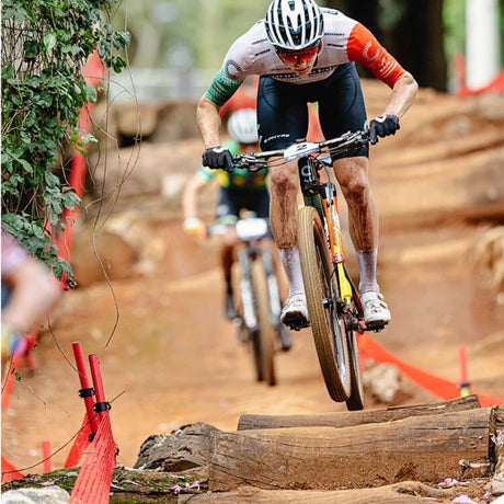 Rider jumping a log on a Cannondale Scalpel cross-country mountain bike